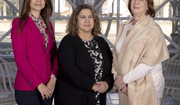 Three women pose for a photo. 