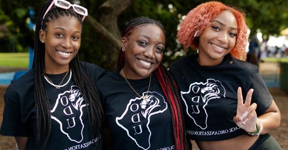 Three students standing together smiling